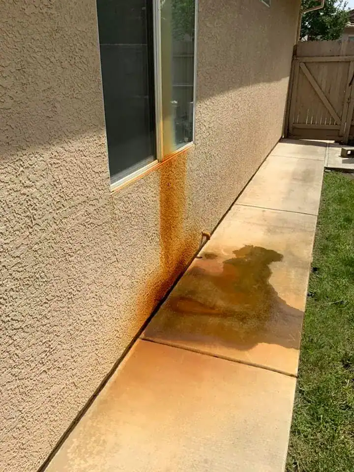 home in phoenix arizona with rust on the wall and sidewalk from a clogged ac drain neglected for a long time